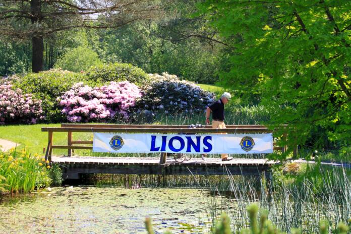 Holzbrücke mit Lions Club Banner im Park